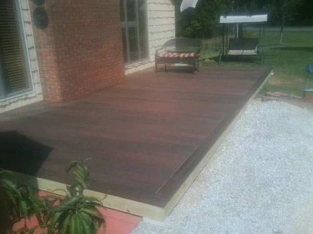 Freshly stained wood deck built against a brick home in Talmage
